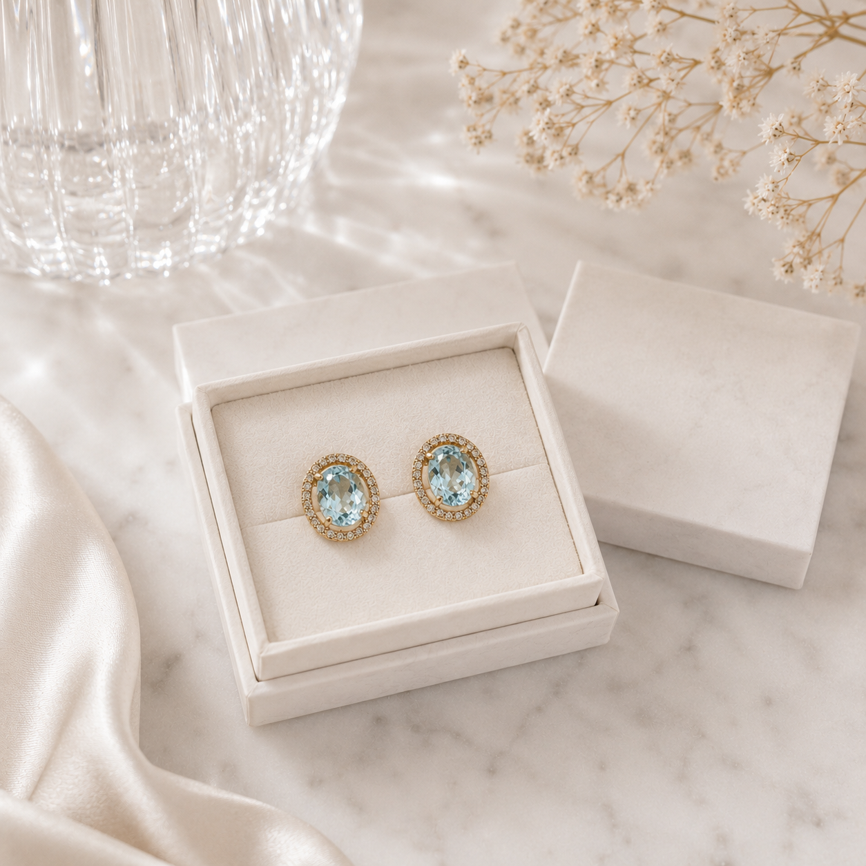 Oval Blue Topaz Halo Stud Earrings in Yellow Gold